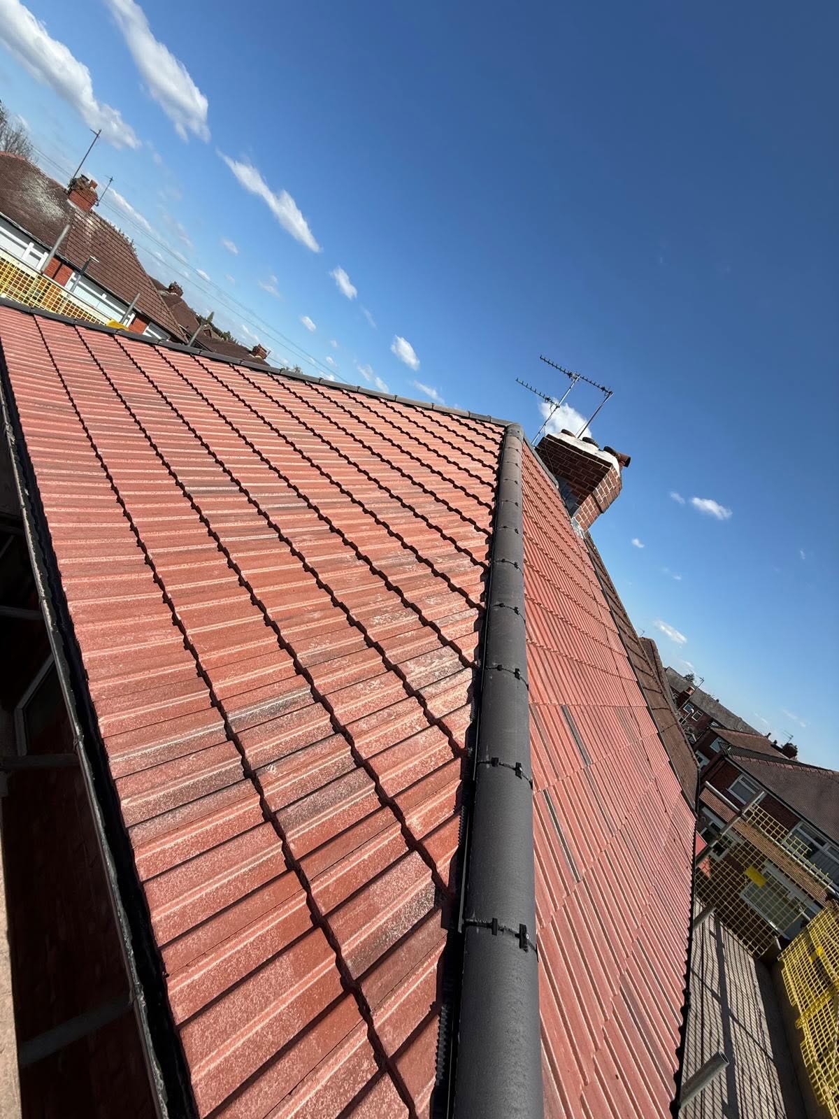 New ridge fitted along a red tile roof
