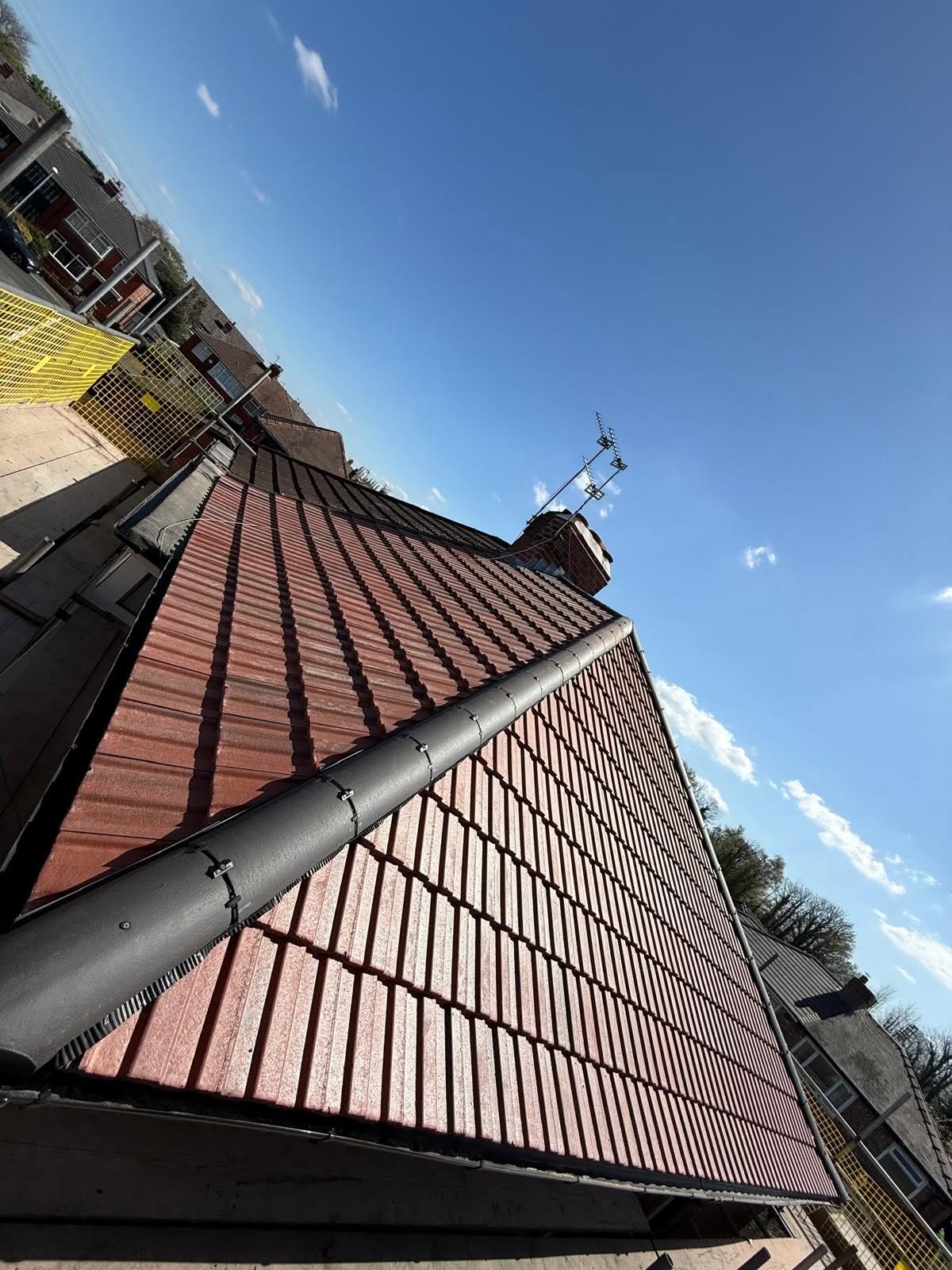Finished red tile roof and ridge in sunshine
